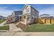 Two-story gray house with orange door, wooden fence, and small front yard at 10291 E 62Nd Pl, Denver, CO 80238