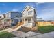 Two-story gray house with orange door, wooden fence, and small front yard at 10291 E 62Nd Pl, Denver, CO 80238