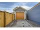 Attached garage with orange door and gravel driveway at 10291 E 62Nd Pl, Denver, CO 80238