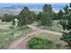 Gravel driveway leading to a unique, round home nestled in the mountains at 3001 Eagle Ridge Rd, Longmont, CO 80503