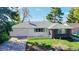 Brick ranch home with a white garage door and landscaped yard at 3067 S Holly Pl, Denver, CO 80222