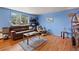 Living room with hardwood floors, blue walls, and a brown leather couch at 1350 Josephine St # 401, Denver, CO 80206
