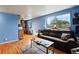 Living room with hardwood floors, blue walls, and a brown leather couch at 1350 Josephine St # 401, Denver, CO 80206