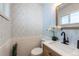 Updated half bathroom with patterned wallpaper and modern fixtures at 177 Wolff St, Denver, CO 80219