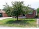 Brick ranch house with a tree and well-maintained lawn at 177 Wolff St, Denver, CO 80219
