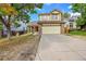 Two story house with a yellow exterior, two car garage and landscaping at 19873 E Vassar Ave, Aurora, CO 80013