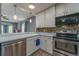 Kitchen with white cabinets, stainless steel appliances, and tiled floor at 6352 S Johnson St, Littleton, CO 80123