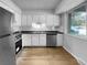 Kitchen features white cabinets, stainless steel appliances, and light flooring at 5670 S Lowell Blvd, Littleton, CO 80123