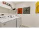 Laundry room with a Whirlpool washer and dryer and convenient shelving at 4213 Sandstone Dr, Mead, CO 80504