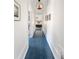 Long hallway with blue floors, white walls, and views into bedrooms at 655 N Humboldt St, Denver, CO 80218