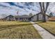 Gray ranch house with landscaped lawn and walkway at 7000 S Sheridan Blvd, Littleton, CO 80128