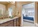 Bathroom with granite countertops, double sinks, and a view of the bedroom at 830 W 128Th Pl, Westminster, CO 80234