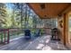 Deck with wooded views, chairs, and a grill at 28192 Shadow Mountain Dr, Conifer, CO 80433