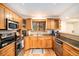 L-shaped kitchen with wood cabinets, granite countertops, and stainless steel appliances at 28192 Shadow Mountain Dr, Conifer, CO 80433