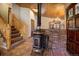 Entryway with wood-burning stove, brick wall, and log staircase at 11608 Apache Trl, Conifer, CO 80433