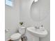 Clean and modern bathroom with pedestal sink and round mirror at 4072 N Rome St, Aurora, CO 80019