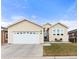 Beige house with a two-car garage and landscaping at 6280 Indian Paintbrush St, Frederick, CO 80530