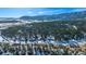 Community overview, showcasing houses nestled in a snow-dusted wooded area with mountain views at 4285 Mohawk Dr, Larkspur, CO 80118