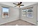 Bright bedroom with two windows, ceiling fan, and neutral walls at 4285 Mohawk Dr, Larkspur, CO 80118