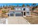 Two-story house with gray siding, two-car garage, and a landscaped yard at 4285 Mohawk Dr, Larkspur, CO 80118