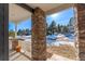 Stone pillars and white railing on a front porch with a view of neighborhood at 4285 Mohawk Dr, Larkspur, CO 80118