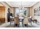 Dining room with a wooden table, chandelier, windows showcasing scenic views, and a bench at 16730 Golden Hills Rd, Golden, CO 80401