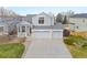 Two-story house with a three-car garage and snowy yard at 4423 S Kalispell Cir, Aurora, CO 80015