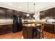 Modern kitchen with dark cabinetry, an island, and stainless steel appliances at 10165 Dover St, Firestone, CO 80504