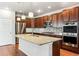 Modern kitchen with dark wood cabinets, granite countertops, and stainless steel appliances at 7095 S Titus St, Aurora, CO 80016