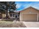 Tan house with attached garage and landscaping at 16812 E Mansfield Cir, Aurora, CO 80013