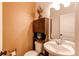 Small powder room with toilet, sink, and storage cabinet at 10303 Pitkin Ct, Commerce City, CO 80022
