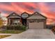Two-story house with beige siding, a three-car garage, and landscaping at 10303 Pitkin Ct, Commerce City, CO 80022
