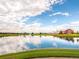 Scenic community pond with a fountain and a red barn clubhouse in the background at 10303 Pitkin Ct, Commerce City, CO 80022