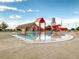 Community pool with a water playground, slide, and a large grassy area at 10303 Pitkin Ct, Commerce City, CO 80022