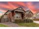 Ranch-style home with red and stone exterior, showcasing a nicely landscaped front yard at 10303 Pitkin Ct, Commerce City, CO 80022