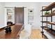 Modern home office with wood desk, built-in shelving, and barn door at 4107 Bryant St, Denver, CO 80211