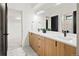 Double vanity bathroom with light wood cabinets and geometric tile floor at 4107 Bryant St, Denver, CO 80211