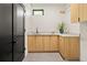 Modern laundry room with light wood cabinets and quartz countertops at 4107 Bryant St, Denver, CO 80211