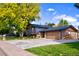 House exterior with a metal roof, attached garage, and landscaping at 6039 W Fair Dr, Littleton, CO 80123