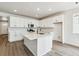 Modern kitchen with white cabinets, island, and stainless steel appliances at 684 Penn Rd, Elizabeth, CO 80107