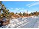 View of the home's back elevation and snowy backyard landscape at 824 W Geddes Cir, Littleton, CO 80120