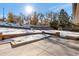 View of the backyard with tiered retaining walls and snowy landscape at 824 W Geddes Cir, Littleton, CO 80120