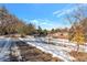 Snowy backyard view with a partially visible home and a white fence at 824 W Geddes Cir, Littleton, CO 80120