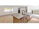 Kitchen island with marble countertop and a farmhouse sink at 824 W Geddes Cir, Littleton, CO 80120