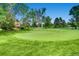 Landscaped putting green with surrounding trees and grass at 3184 S Heather Gardens Way # 302, Aurora, CO 80014