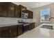 Modern kitchen with dark cabinets, stainless steel appliances, and white countertops at 8378 E 132Nd Pl, Thornton, CO 80602