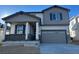 Two-story house with gray siding, a two-car garage, and a covered front porch at 9103 Truckee Ct, Commerce City, CO 80022