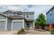 Two-story townhome with gray siding and a double car garage at 762 Mockingbird Ln, Brighton, CO 80601