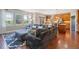 Open living room with hardwood floors, large sectional sofa, and kitchen views at 6988 S Riverwood Way, Aurora, CO 80016