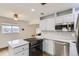 Eat-in kitchen with stainless steel appliances and white cabinets at 9030 Hickory Pl, Thornton, CO 80229